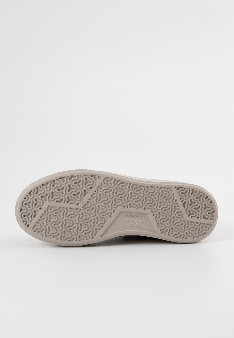 Schuhsohle mit einem strukturierten, hellgrauen Gummidesign, das ein wellenförmiges Muster und einen dreieckigen Akzent aufweist. Flaches Profil für Stabilität.