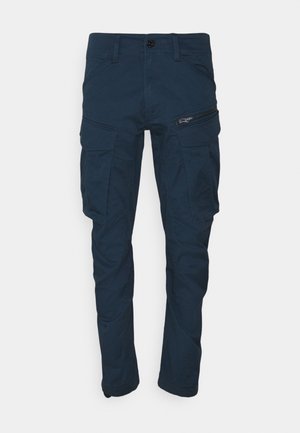 Pantalones cargo azul marino con botón frontal, trabillas para cinturón, bolsillos laterales con solapa y un bolsillo con cremallera en el muslo derecho.