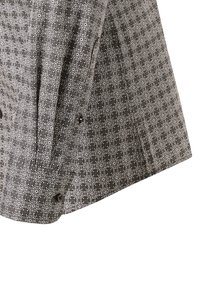 Camicia a maniche lunghe bianca e nera con un motivo floreale geometrico e bottoni neri ai polsini e alla patta delle maniche.