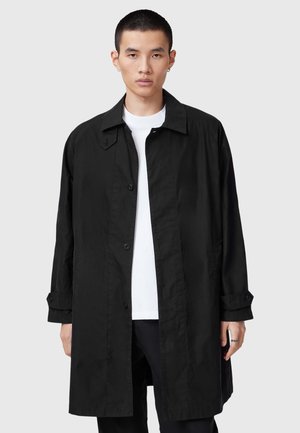 Cappotto trench leggero nero con collo a camicia, chiusura a bottoni e tasche laterali; presenta maniche arrotolate e una texture liscia.