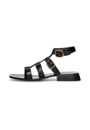 Czarne sandały ze skóry z wielopaskowym designem, regulowanym paskiem wokół kostki z klamrą w złotym kolorze oraz niskim obcasem na klocku. Gładka faktura.