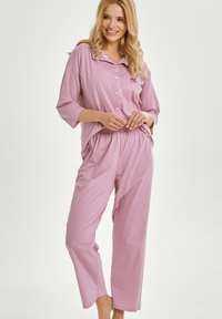 Czerwono-biały w kratkę zestaw piżamowy z koszulą na kołnierzyku, zapinany na guziki oraz luźne spodnie. Miękki materiał z luźnym fasonem.