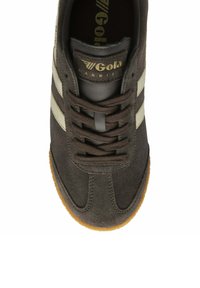 Baskets en suede gris foncé avec des rayures blanches, lacets plats et semelle en caoutchouc crémeux. Présente une surface texturée et une étiquette de langue de marque.