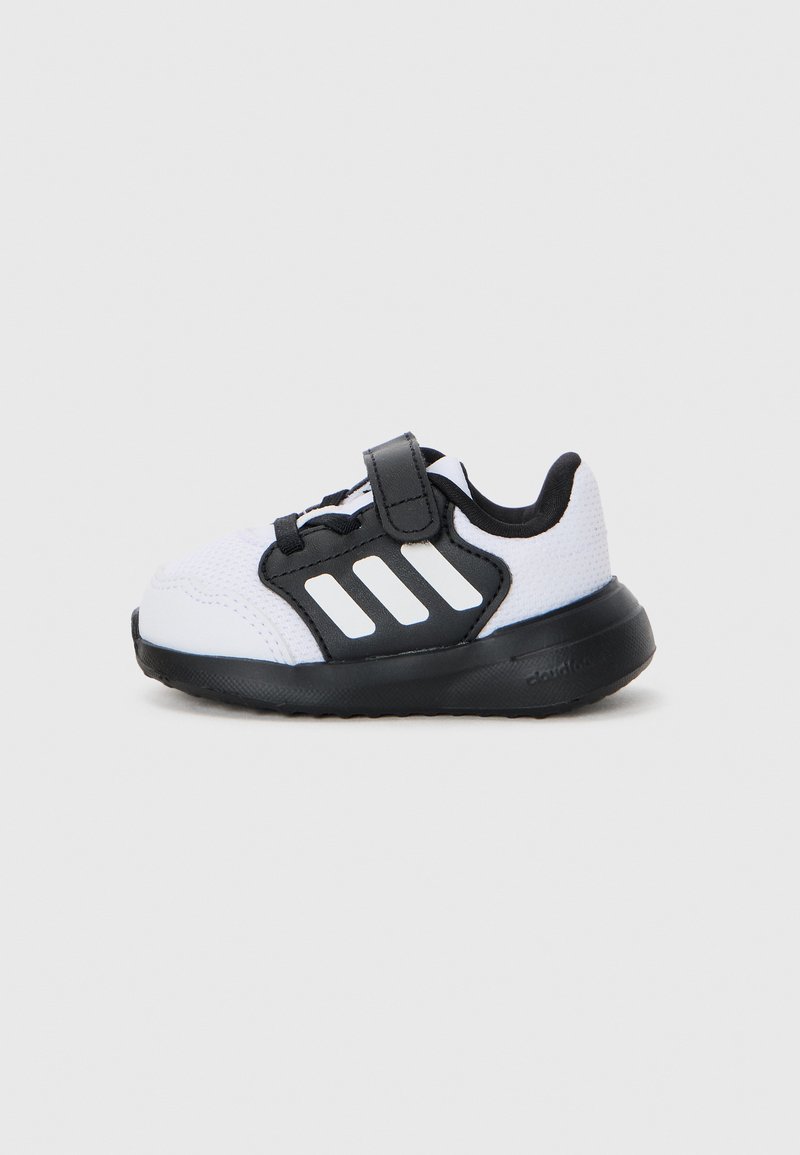 Schwarzer und weißer Sneaker mit einem Obermaterial aus Mesh, Klettverschluss und schwarzer Sohle. Mit drei weißen Streifen an der Seite.