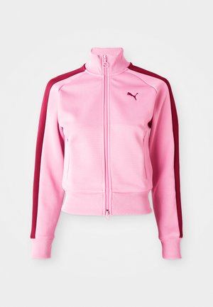 Rosa zip-up jakke med høyt krage, med burgunder sidestreker og en liten logo på venstre brystområde. Hvit bakgrunn.