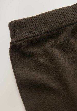 Brauner Baumwollmischgewebe-Stoff mit einem gerippten Bund, der eine weiche Textur und eine glatte Oberfläche zeigt, gefaltet, um seine Form und Designmerkmale hervorzuheben.