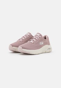 Scarpe da ginnastica in rete rosa pallido con accenti bianchi, design a lacci, superficie texture e suola ammortizzata per il comfort.