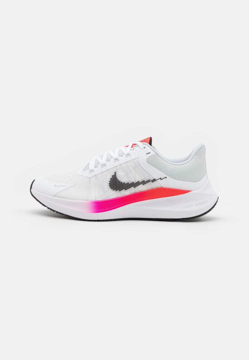 Chaussure de course blanche Nike avec un swoosh noir, une semelle intermédiaire dégradée rose, des lacets blancs et un col de talon rembourré gris sur fond blanc.