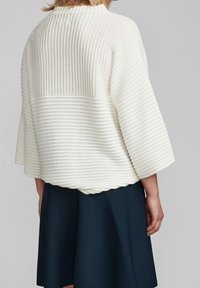 Sweter w kolorze kremowym, prążkowany, z wysokim dekoltem i rękawami 3/4, z teksturowanym wzorem i falbaniastym dołem.