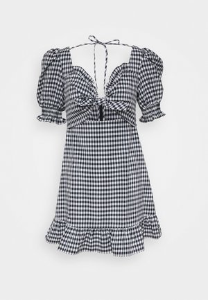 Mini sukienka w czarno-białą kratkę gingham z bufiastymi rękawami, kokardą z przodu, kwadratowym dekoltem i falbaną na dole.