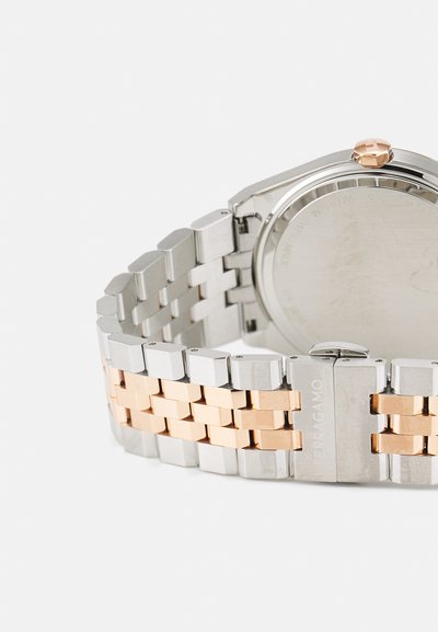 Silver and rose gold metal watch band with rectangular links. The watch back exhibits a simple, smooth surface without markings.