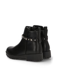 Botines negros de cuero liso con una correa tachonada con detalles en forma de estrella y una suela resistente para mejorar el agarre.