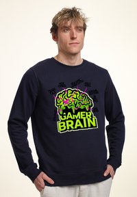 Felpa blu navy realizzata in tessuto morbido, con una grafica audace di un cervello verde con accenti rosa e il testo "GAMER BRAIN" in un giallo intenso.