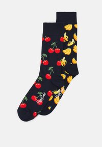 Chaussettes bleu marine ornées de cerises rouges sur une chaussette et de bananes jaunes sur l'autre, fabriquées en coton doux avec des bords côtelés et un détail de logo.