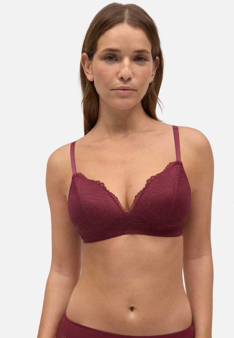 Bralette de encaje burdeos con un profundo escote en V, bordes en forma de concha y tirantes ajustables. Textura suave con un detalle de patrón floral.