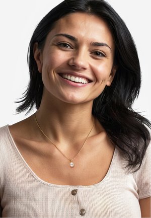 Collana d'oro con un pendente a goccia che presenta una perla, indossata su un top a righe leggero, che mostra un design semplice ed elegante.