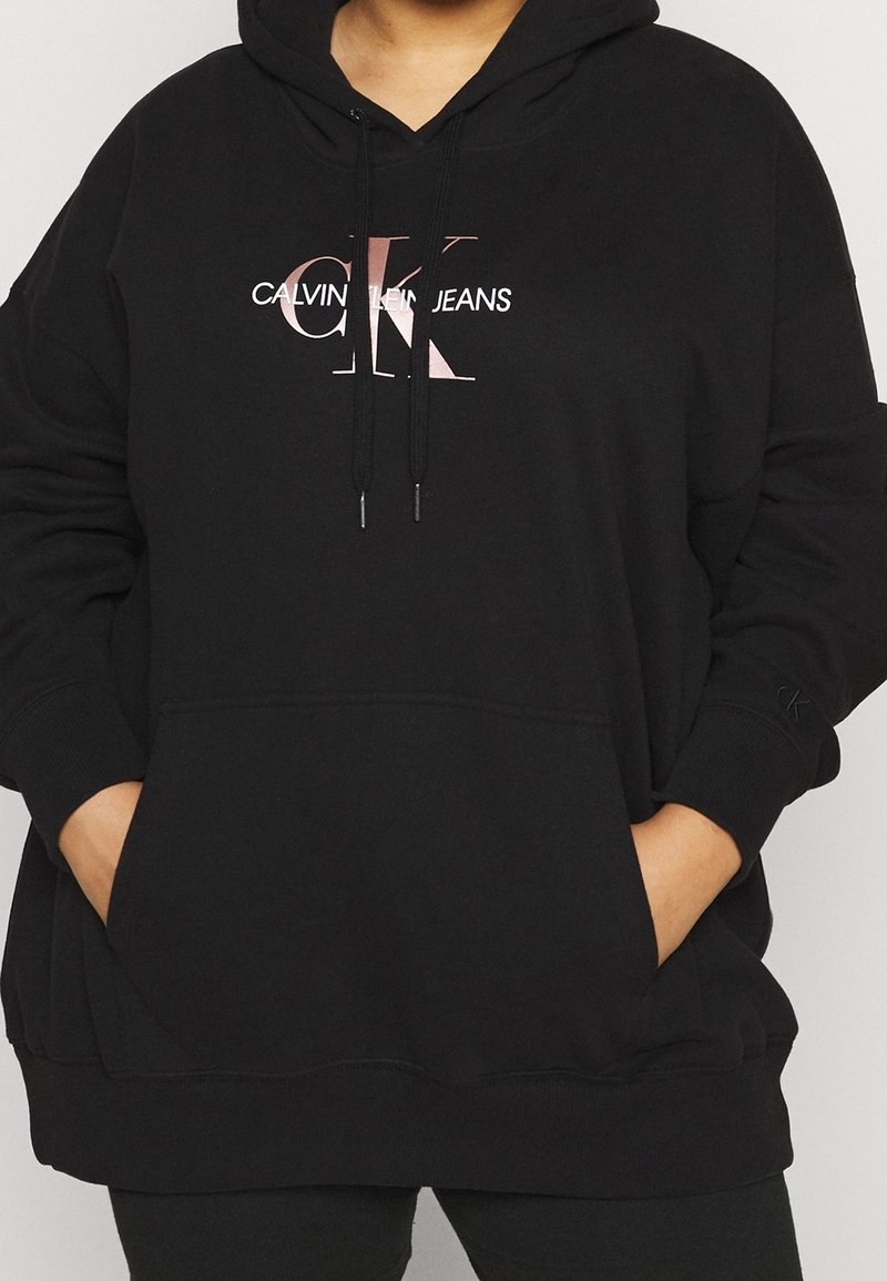 Czarna bluza z kapturem, z kieszenią kangurką z przodu, ściągaczem i nadrukiem z logo w kolorze białym i różowym na piersi.