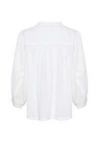 Blouse blanche à manches longues avec une texture délicate à pois, coupe ample, empiècement dos froncé et manches avec poignets boutonnés.