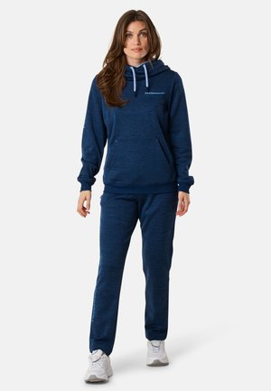 Sweatshirt à capuche bleu marine avec une poche avant et des cordons de serrage, assorti d'un pantalon de survêtement, le tout en tissu texturé.