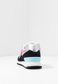 Baskets en suede noir avec des accents argentés, panneau en maille rose et semelle bleu clair. Présente un talon rond et un profil en caoutchouc pour l'adhérence.