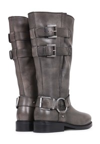 Botas altas de cuero gris con tres hebillas plateadas ajustables y un tacón bajo negro, mostradas desde los ángulos trasero y lateral.