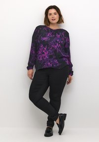 Zwarte bloempatron blouse met lange mouwen, featuring paarse bloemen, een ronde hals en een gebogen zoom, gecombineerd met slim-fit zwarte broek en gepatenteerde instappers.