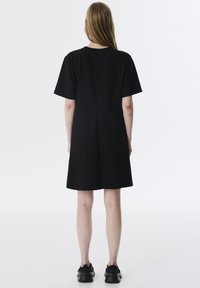 Schwarzes Kurzarmkleid mit gerader Silhouette, aus einem glatten Stoff gefertigt. Verfügt über einen geraden Saum und einen einfachen Rundhalsausschnitt.