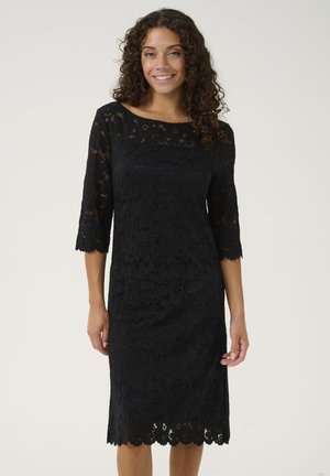 Robe en dentelle noire avec des manches trois-quarts, motif floral, ourlet festonné et décolleté bateau. Texture lisse avec des détails complexes.