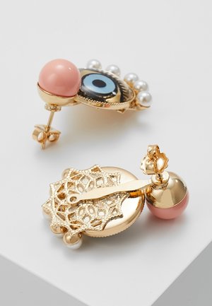 Boucles d'oreilles dorées avec des clous sphériques roses, dont une présente un motif d’œil bleu entouré de petites perles et des détails en filigrane au dos.