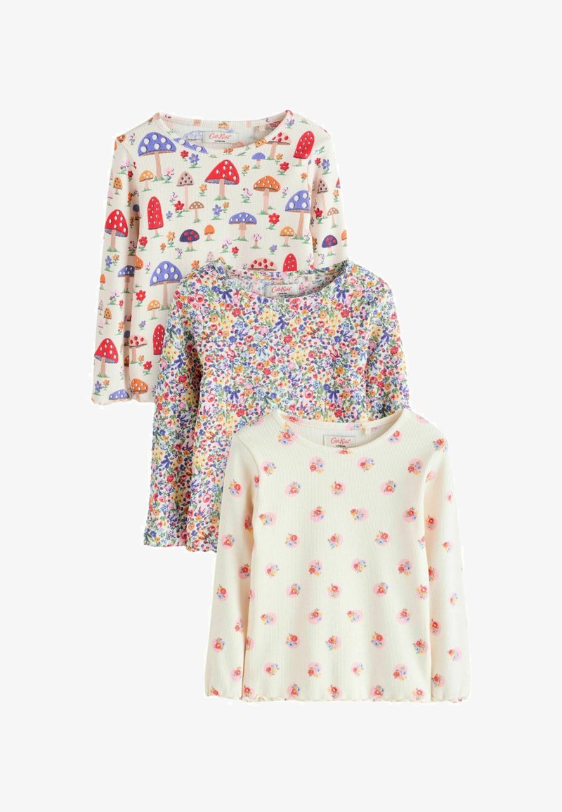 Trois hauts pour enfants à manches longues avec col arrondi ; un avec un imprimé champignons coloré, un avec un imprimé floral petit et dense, et un avec de petites fleurs éparpillées.