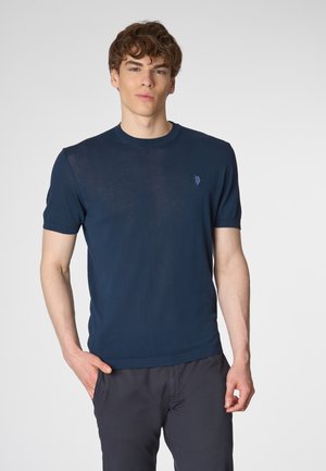 T-shirt a maglione blu navy con maniche corte e scollatura a girocollo. Presenta un piccolo logo ricamato sul petto sinistro. Texture morbida.