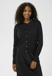 Schwarze gestrickte Strickjacke mit Rundhalsausschnitt, silberfarbenen Knöpfen auf der Vorderseite sowie gerippten Bündchen und Saum. Die strukturierte Stoffqualität fügt dezente Details hinzu.