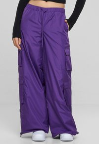 Lila Cargo-Hosen aus glattem, leichtem Stoff; verfügen über mehrere Seitentaschen, eine lockere Passform und einen elastischen Taillenbund.