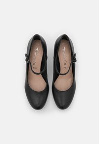 Svarta läderballetskor med rund tå, utskärning på sidan och en dekorativ ankelrem, med en jämn yta och vadderad innersula.