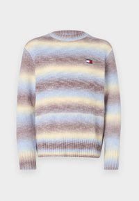 Pull en tricot à rayures horizontales marron, bleu clair et jaune. Il présente un col rond ainsi que des poignets et un ourlet côtelés. Petite patch logo sur la poitrine.
