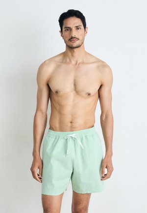 Grüne, gestreifte Badeshorts mit einem elastischen Bund und Kordelzug, aus leichtem Stoff gefertigt, mit einer lockeren Passform und einer Länge über dem Knie.