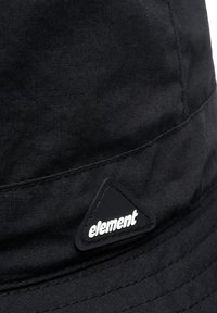 Sort bøttehat lavet af stof med en glat tekstur. Har et trekantet logo-lap i hvid på sort, med synlige syninger.
