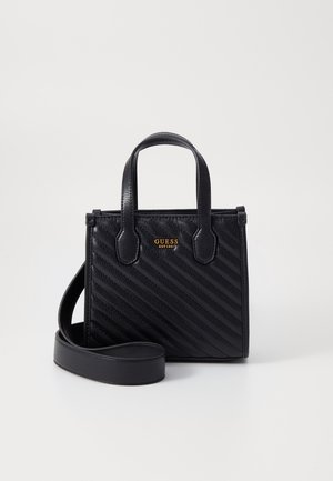 Sac à main noir Guess avec texture en chevrons, deux poignées et bandoulière amovible sur fond blanc.