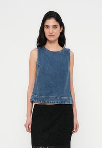 Τοπ τζιν χωρίς μανίκια σε σκούρο μπλε με στρογγυλή λαιμόκοψη και ακατέργαστο τελείωμα. Το υλικό έχει υφή. Συνδυασμένο με φούστα από μαύρη δαντέλα.