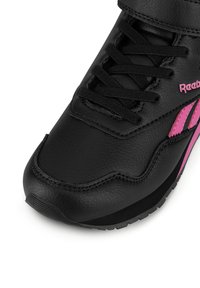 Černé kožené tenisky Reebok s černými tkaničkami a růžovými detaily loga, zobrazené z blízka z předního úhlu.