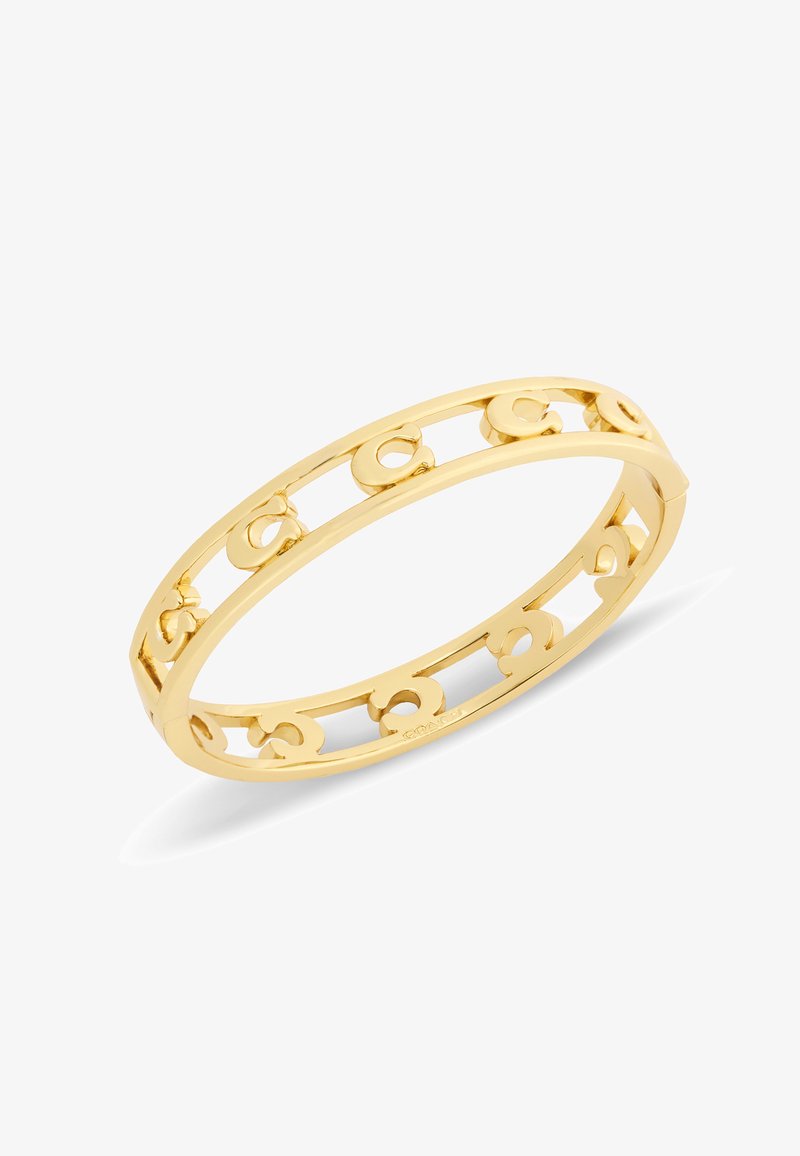 Bracelet jonc en or avec un design en ajour présentant des formes répétées de "C" et une finition polie lisse.