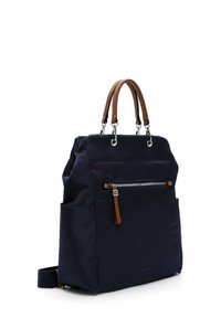 Sac à dos bleu marine avec poignées en cuir marron, poche avant zippée, poches latérales et bretelles ajustables.