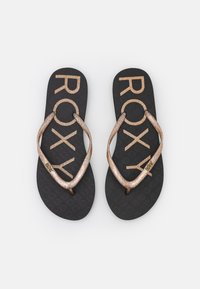 Roxy sussid on must kummist tald, millel on tekstuuriga muster. Rihmad on roosakuldsed, sädelevad ja ristuvad V-kujulises vormis.