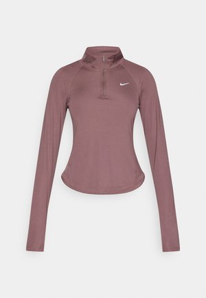 Pitkähihainen urheilupaita sävystä murrettu lila, jossa on puolivetoketjullinen kaulus, sileä kangas, kaartuva helma ja hillitty Nike-logo rinnassa.