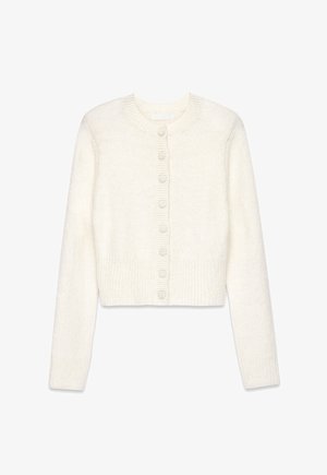 Cárdigan blanco corto hecho de un tejido de punto suave. Presenta un escote redondo, mangas largas y seis botones a juego en la parte delantera.