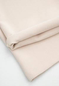 Beżowy materiał o teksturowanej powierzchni, złożony na sobie. Posiada starannie szyte krawędzie i gładkie wykończenie.