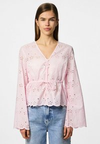 Lyserød bluse med V-hals, lange klokkeærmer, hulmønster med blomster, indsnævret talje med snor og bølget kant.