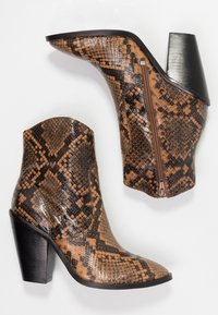Botas de tobillo con patrón marrón y negro, confeccionadas en material brillante estilo serpiente, con un tacón cuadrado y un detalle de cremallera lateral.