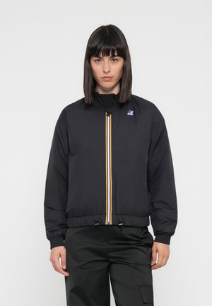 Veste légère noire avec col montant, zip à l'avant et rayures contrastantes jaune et blanche. Détails élastiques aux poignets et à l'ourlet.