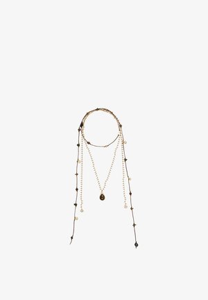 Dlhý viacvrstvový náhrdelník so svetlohnedými šnúrkami, malými korálkami a príveskom v tvare slzy v strede na bielom pozadí.